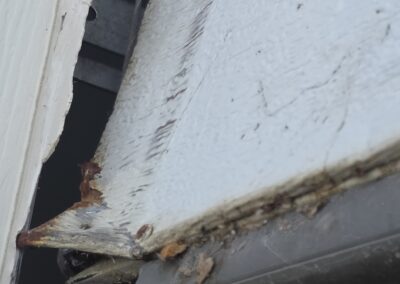 A garage door panel damaged and comin apart due to rust.